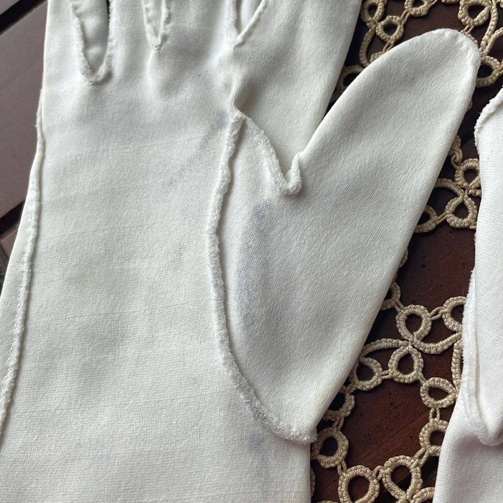 Beautiful delicate vintage white gloves with floral accents.